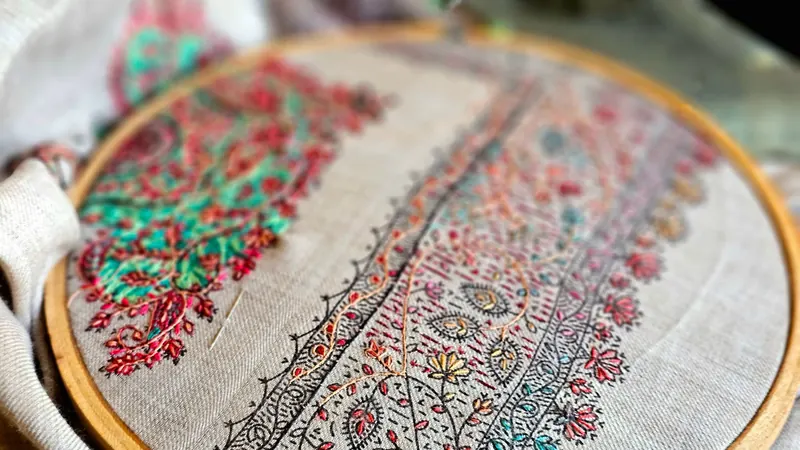 Colorful hand embroidery in progress on a fabric hoop, showcasing detailed craftsmanship