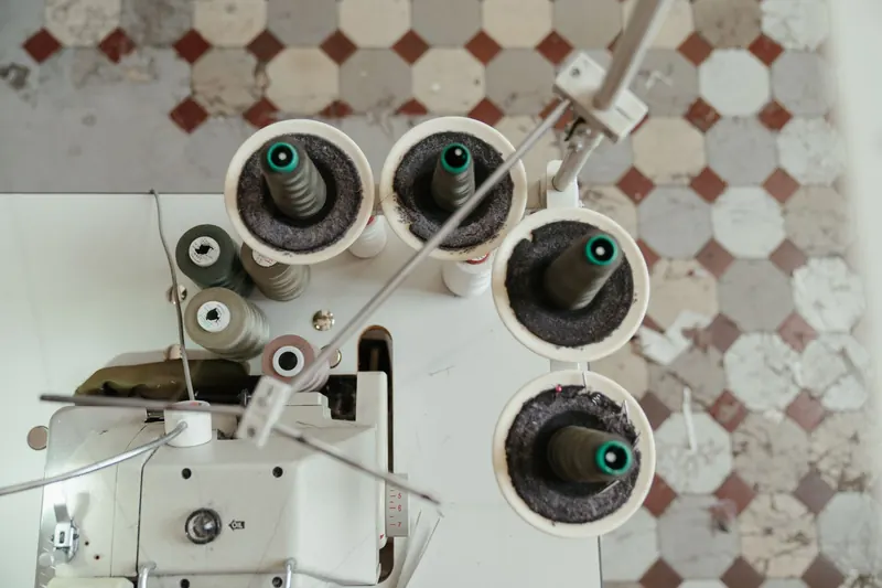 Aerial view showcasing the setup of a sewing machine with thread spools, perfect for textile industry content