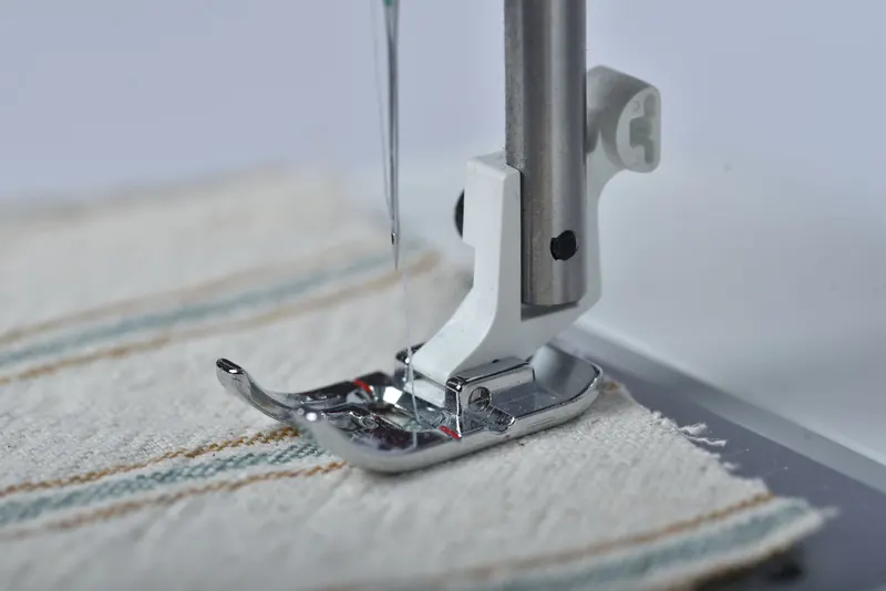 Detailed view of a sewing machine needle working on fabric, showcasing precision and craftsmanship