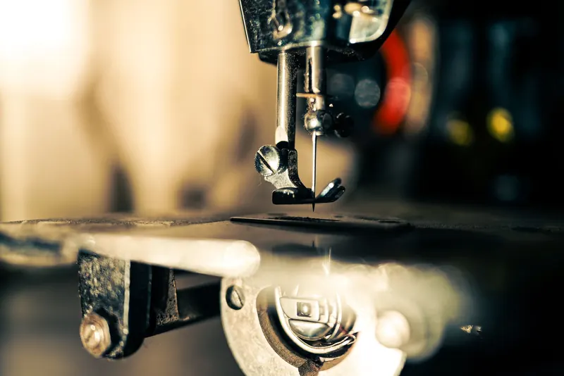 Detailed image of a vintage sewing machine needle. Perfect for themes related to craftsmanship and tailoring