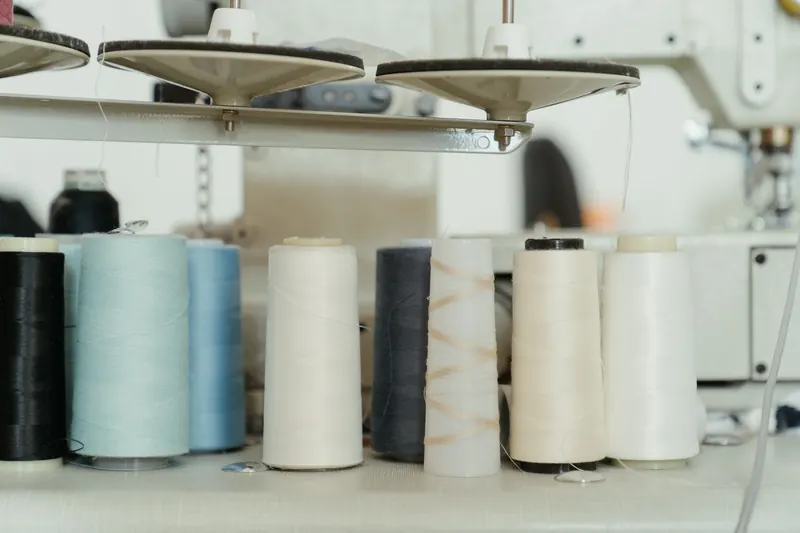 A variety of colorful thread spools on a sewing machine in a workshop setting