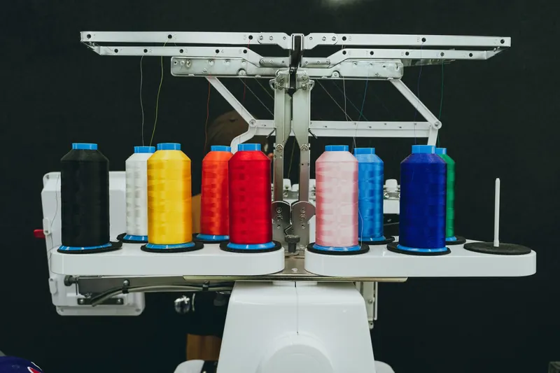 Close-up of colorful thread spools on an industrial embroidery machine in a textile workshop
